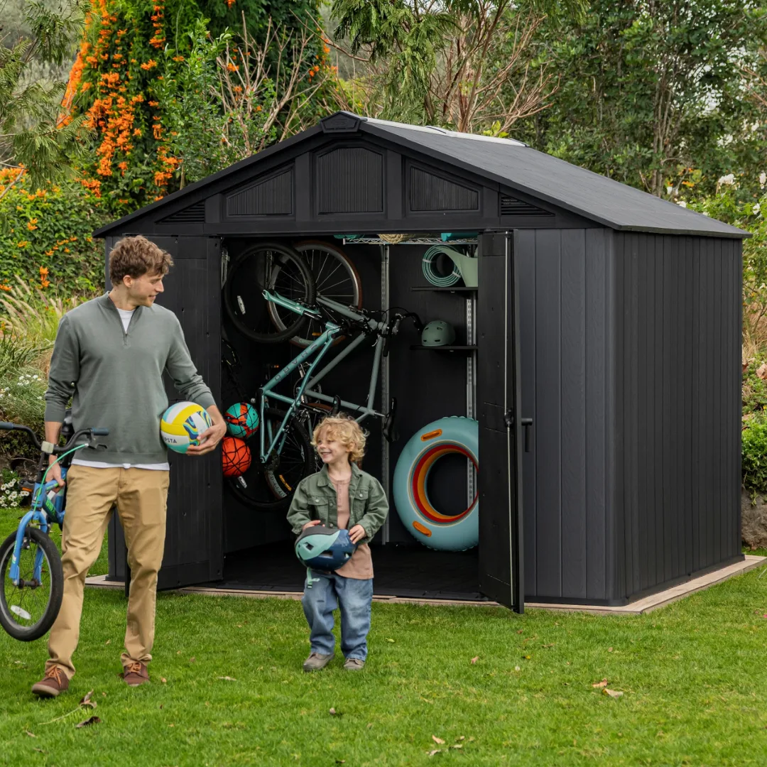 Family walking past a Keter Stronghold shed on a lawn